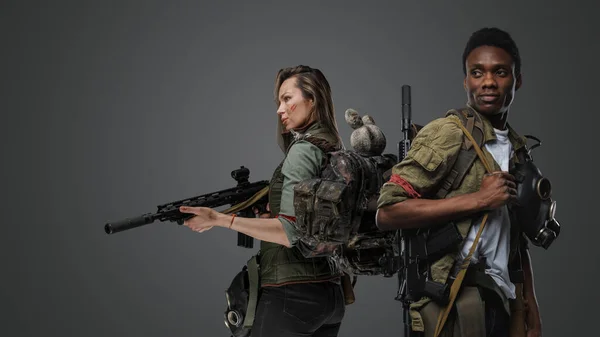 灰色の背景に孤立したライフルを持つ黒人男性と白人女性のショット — ストック写真