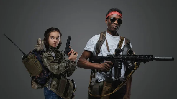 女の子のショットとともに拳銃と黒男とともにライフルとともにグレーの背景 — ストック写真