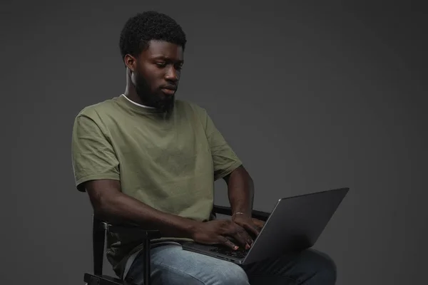 Studio Shot Van Zwarte Man Met Laptop Zittend Stoel Tegen — Stockfoto