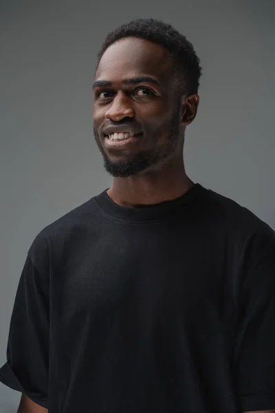 スタジオショットの笑顔黒男でスタイリッシュな髪型でTシャツ — ストック写真
