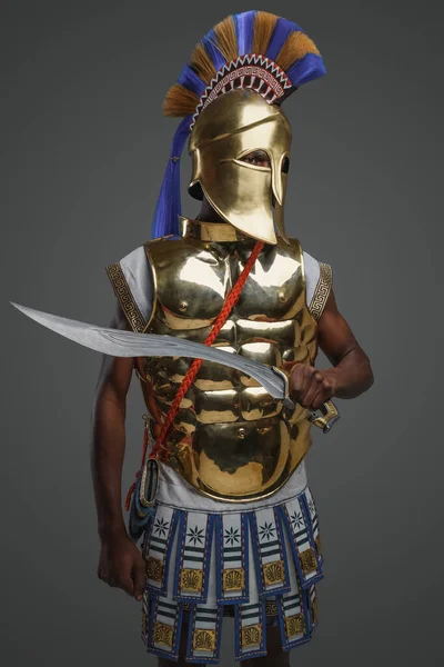 灰色の背景に黄金の鎧と黒ギリシャの戦士のショット — ストック写真