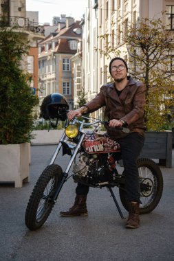 Deri ceketli, şık özel motosikletli modaya uygun adamın fotoğrafı..