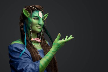 Yeşil derili ve gri arkaplanlı büyülü elf Druid 'in stüdyo fotoğrafı..