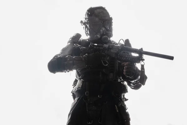 バックライト付きの白い背景にライフルとガスマスクを持つ軍の男のショット — ストック写真