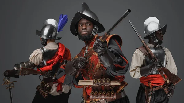 鋼製の武器を持つ3人の征服者とフリントロックライフルの多民族集団の肖像 — ストック写真