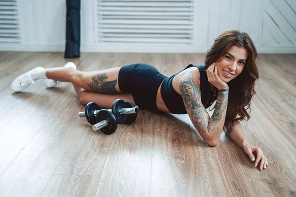 Ubrana Czarne Sportowe Tatuaż Fitness Dziewczyna Stanowi Leżące Podłodze Wokół — Zdjęcie stockowe