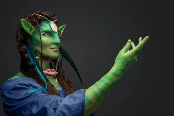 stock image Studio shot of magical elf druid with green skin and jewelry against grey background.