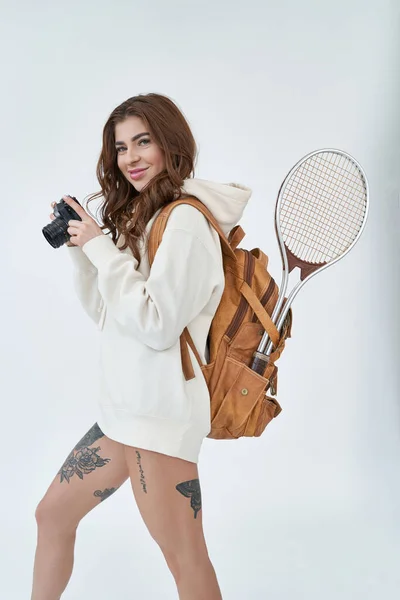 一个快乐漂亮的女运动员提着手提包 拿着白色背景的照相相机的画像 — 图库照片