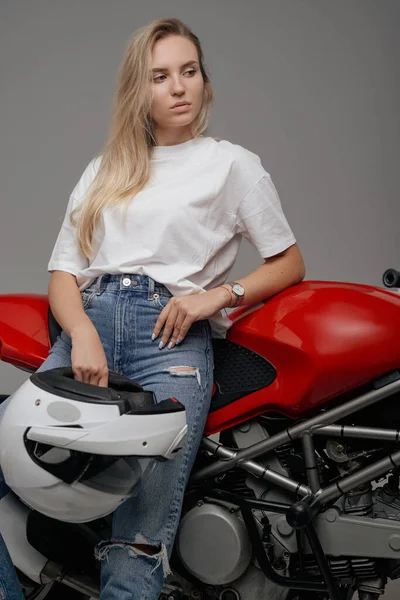 スタジオショットのブロンド髪の女性オートバイ周りカスタムバイク保持ヘルメット — ストック写真