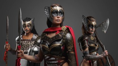 Gri arka planda zırh giymiş üç eski savaşçının fotoğrafı..