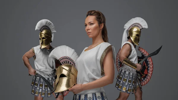 アンティークギリシャの戦士の女性と軍の男性はチュニックを身に着けているとヘルメットを急落 — ストック写真