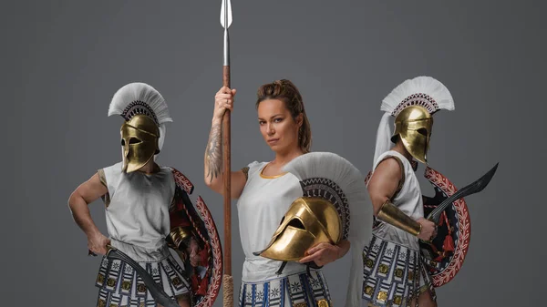 アンティークギリシャの戦士の女性と軍の男性はチュニックを身に着けているとヘルメットを急落 — ストック写真