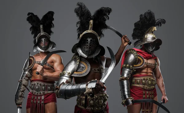 Studio shot of antique roman warriors dressed in armors and plumed helmets.