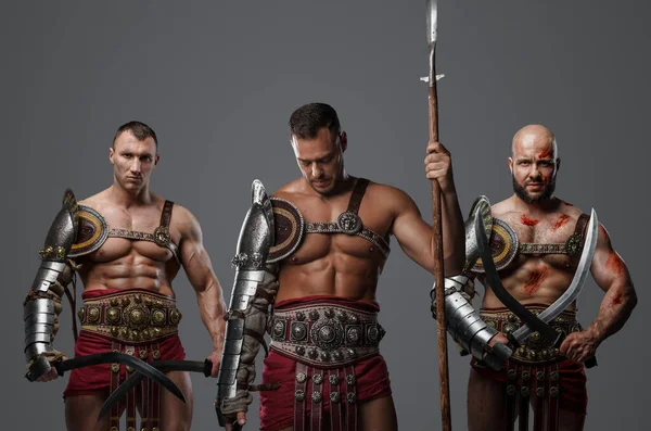 Portrait of three gladiators from ancient rome looking at camera together.