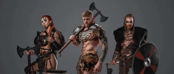 Shot of muscular viking with female and male barbarians with weapons.