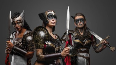 Demir zırhlar giymiş üç çekici kadın savaşçının portresi..