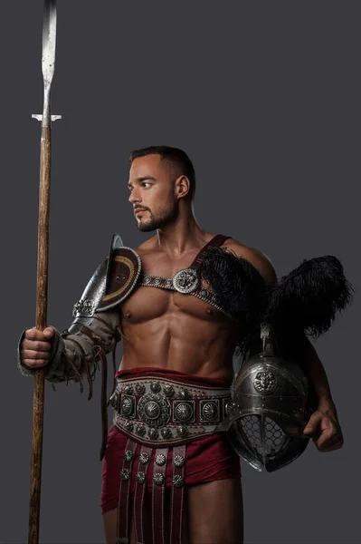 强壮而优雅的角斗士身穿轻薄的盔甲 高高地站在那里 手持长矛 在中立的背景上展示他的羽毛头盔 — 图库照片