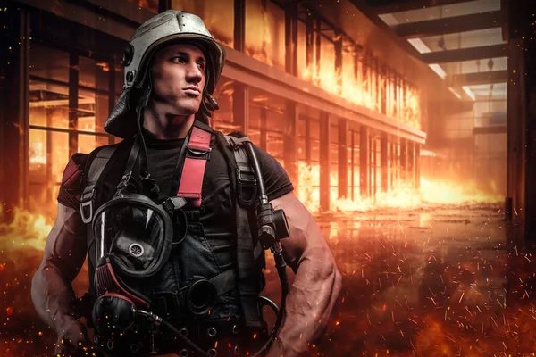オフィスビルの中で炎と煙を吹いている間に保護制服を着た勇敢な消防士が立っています この写真は緊急時の対応者の勇気と犠牲を示しています — ストック写真