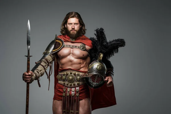 Ein Bärtiger Gladiator Mit Langen Haaren Steht Auf Grauem Grund — Stockfoto