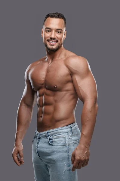 Uroczy Muskularny Model Męski Olśniewającym Uśmiechem Bez Koszulki Neutralnym Szarym — Zdjęcie stockowe