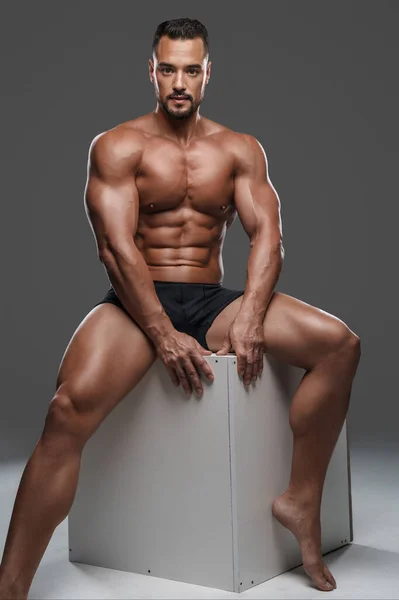 Modelo Masculino Surpreendentemente Bonito Musculoso Cuecas Pretas Senta Cubo Branco — Fotografia de Stock