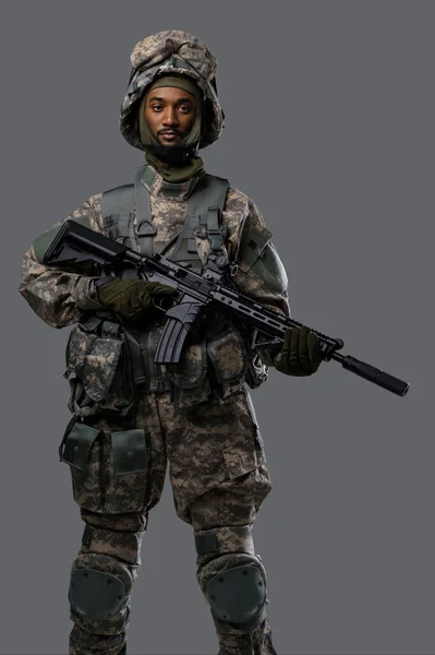 Soldato Fiducioso Uniforme Nato Casco Posa Con Fucile Sfondo Grigio — Foto Stock