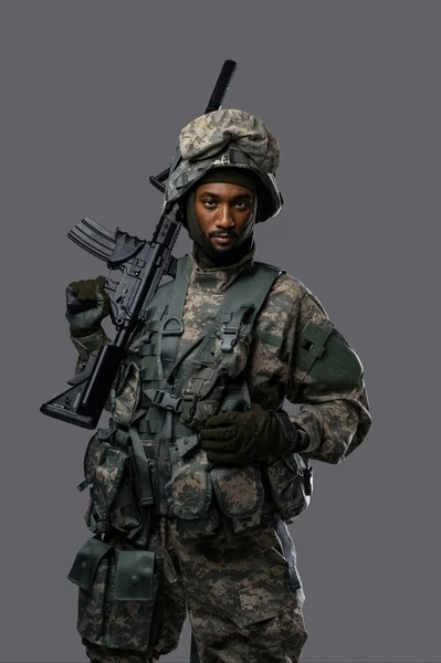 Důvěryhodný Voják Uniformě Nato Helmě Pózuje Puškou Prostém Šedém Pozadí — Stock fotografie
