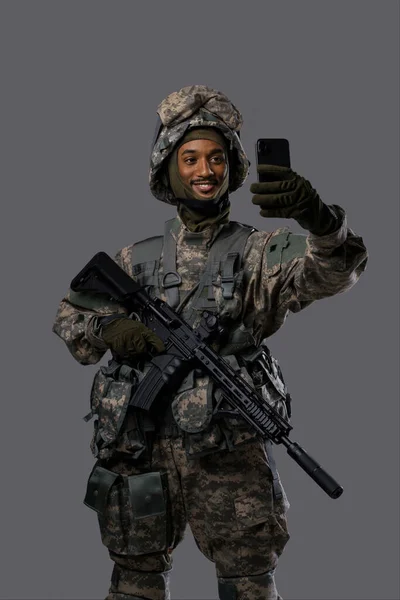 身着制服 头戴安全帽的快乐军人在智能手机上自拍或视频聊天 展现了身着制服士兵的科技技巧和积极向上的一面 — 图库照片