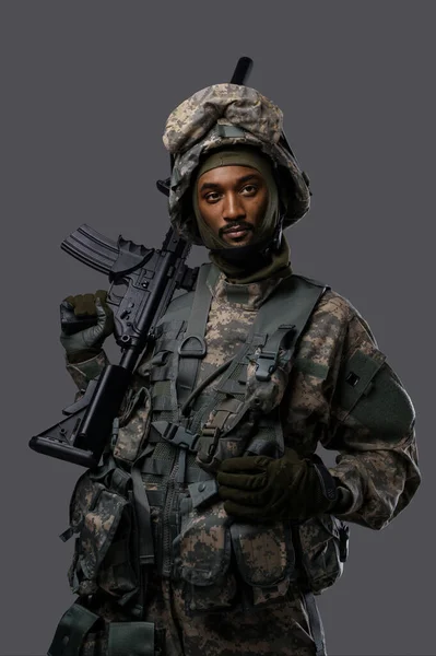 Tmavý Voják Uniformě Nato Helmě Pózuje Vážným Výrazem Prostém Šedém — Stock fotografie