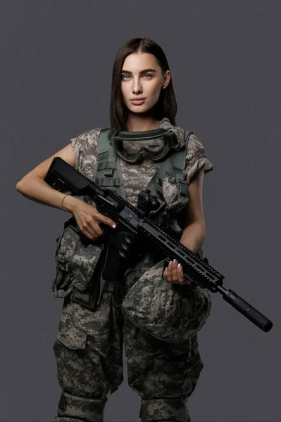 Ohromující Vojačka Vojenské Uniformě Automatickou Puškou Šedém Pozadí Elegantně Pózující — Stock fotografie