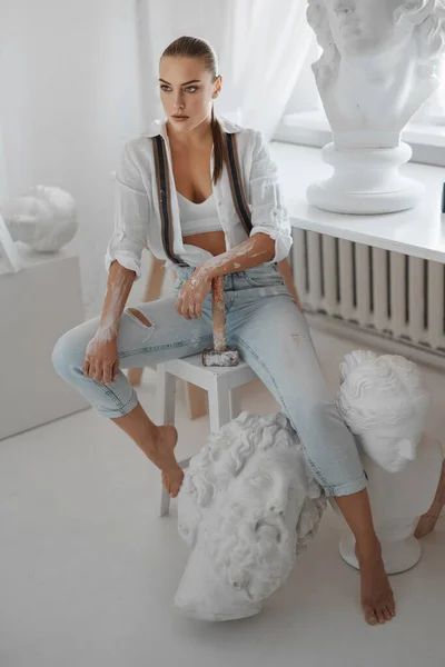 Utalentowana Rzeźbiarka Ubrana Białą Rozpinaną Koszulę Dżinsy Szelkami Trzymająca Młotek — Zdjęcie stockowe