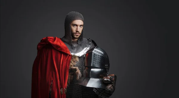 鋼板を装甲した若い王の肖像画 鋼のヘルメットを保持し 赤いクロークを着用し 中立的な背景にポーズ — ストック写真