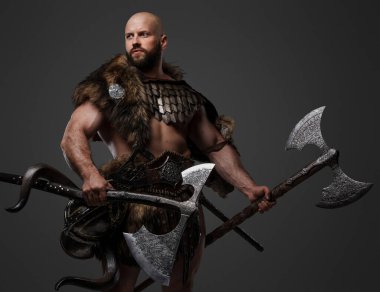 Kel, sakallı bir Viking kürk ve hafif zırh giyiyor, büyük bir balta taşıyor, tarafsız bir arkaplana karşı.