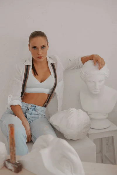 Utalentowana Rzeźbiarka Ubrana Białą Koszulę Dżinsy Szelkami Siedząca Przypadkowo Wśród — Zdjęcie stockowe