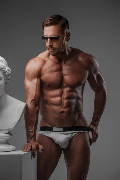 Modelo Masculino Carismático Gafas Sol Ropa Interior Posa Junto Busto — Foto de Stock