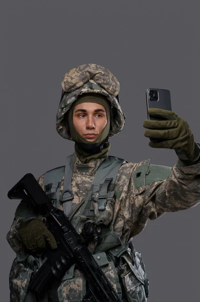 Солдат Пистолетом Мобильным Телефоном Появляется Сделать Селфи Сделать Видеозвонок Сером — стоковое фото
