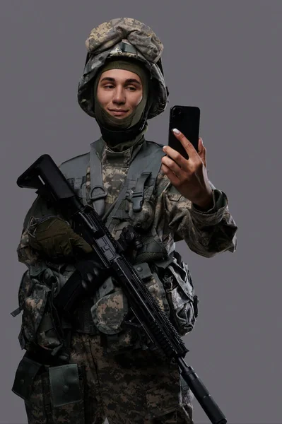 휴대폰을 군인은 셀카를 찍거나 비디오 채팅을하고 군인의 캐주얼하고 현대적인 측면을 — 스톡 사진