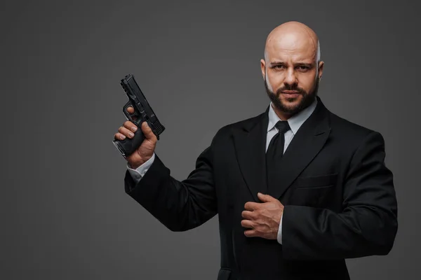 Bald Security Man Suit Holds Gun Ready Protect Gray Studio — Stock Photo, Image