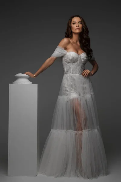 Elegant Woman White Gown Juxtaposed Classical Greek Statues Studio Setting — Stock Photo, Image