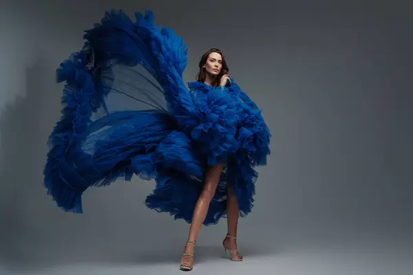Потрясающая Модель Пышном Голубом Карнавальном Платье Элегантно Позирует Сером Фоне — стоковое фото