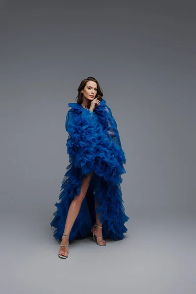 Потрясающая Модель Пышном Голубом Карнавальном Платье Элегантно Позирует Сером Фоне — стоковое фото