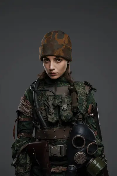 Brave woman soldier with wounded hand in military uniform, symbolizing resistance in a Middle Eastern conflict, on a gray background