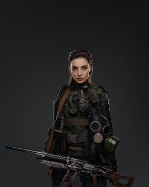 Bir kadın askerin portresi. Elinde ev yapımı otomatik bir tüfek var. Gri bir arka plana karşı Orta Doğu çatışmasında bir isyancıyı ya da partizanı tasvir ediyor.