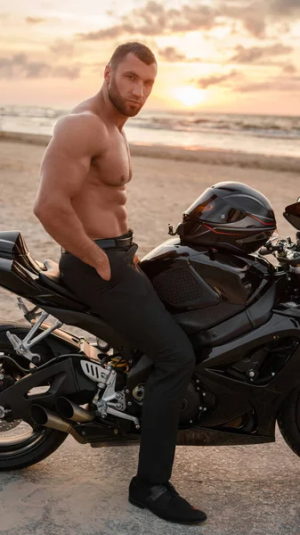 Bonito Homem Rasgado Senta Sua Motocicleta Esportiva Preta Uma Praia — Fotografia de Stock