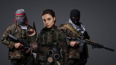 Üç Ortadoğulu militan grubu kamuflaj üniformaları, keffiyehler ve kar maskeleri giyip gri arka planda poz veriyorlar.