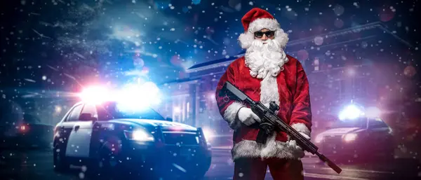 A man dressed as Santa Claus, holding a machine gun, poses in front of police cars with numerous police lights and sirens, amid a snowy stormy night on the street