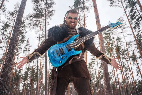 A Viking-inspired musician plays an electric guitar in a snowy forest, embodying a fusion of ancient warrior and modern music culture