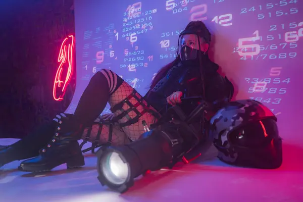 Kvinna Futuristisk Taktisk Svart Kostym Ligger Golvet Med Motorcykel Hjälm — Stockfoto