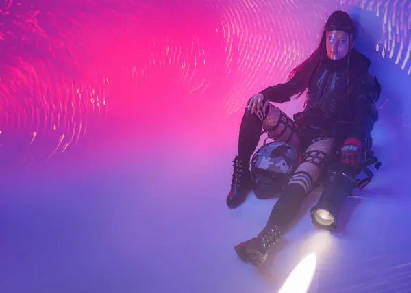 미래의 슈트를 여자는 바닥에 오토바이 헬멧과 거대한 프로젝터는 그녀의 디지털 스톡 사진