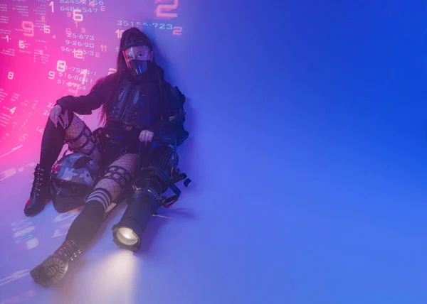 미래의 슈트를 여자는 바닥에 오토바이 헬멧과 거대한 프로젝터는 그녀의 디지털 로열티 프리 스톡 사진